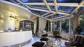 A luxurious room with a glass ceiling, a white bar area, and elegant seating. - Hotel Borgo Antico (Ceprano)