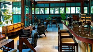A spacious restaurant with high ceilings, large windows, and a variety of seating arrangements. - J Park Hotel (Chonburi)