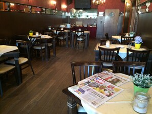 A restaurant interior with wooden flooring, tables, and chairs. - Hotel en Grand Café de Pauw (Roermond)