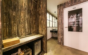 A hallway with a rustic wooden wall, a door with a number, and a window. - February Hotel - Busan Songdo (Busan)
