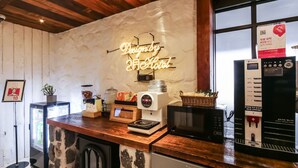 A kitchen area with a neon sign, coffee machine, microwave, and refrigerator. - February Hotel - Busan Songdo (Busan)