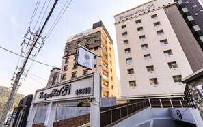 A hotel with a sign indicating it is the second floor, surrounded by other buildings. - February Hotel - Busan Songdo (Busan)