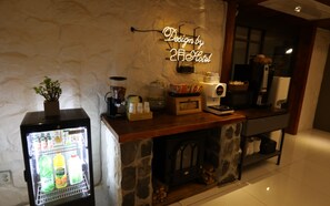 A kitchenette with a coffee machine, a beverage dispenser, and a refrigerator stocked with drinks. - February Hotel - Busan Songdo (Busan)
