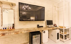 A modern kitchen with a large flat-screen TV, a desktop computer, and a refrigerator. - February Hotel - Busan Songdo (Busan)