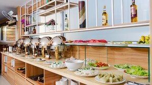 A buffet setup with various food items and condiments. - Dream Hotel Nha Trang (Nha Trang)