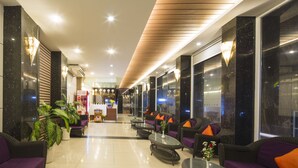 A modern lobby with seating areas, a reception desk, and potted plants. - Dream Hotel Nha Trang (Nha Trang)