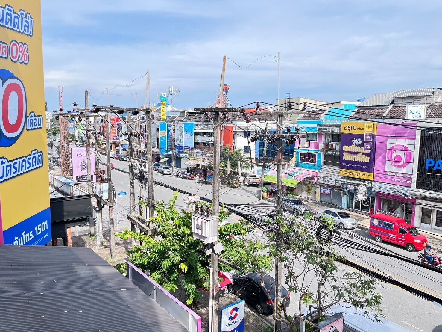 A busy street with various shops and vehicles.