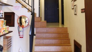 Una escalera con barandilla, un letrero de zona de equipaje y cuadros enmarcados en las paredes.