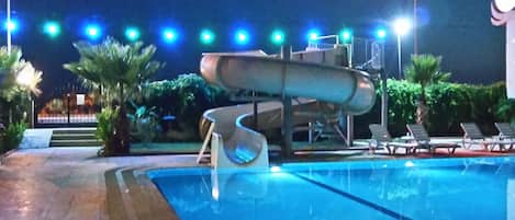 Una piscina al aire libre, sombrillas, tumbonas