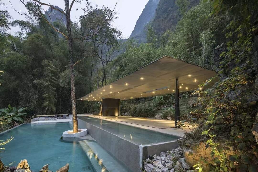 Una piscina al aire libre, una piscina con borde infinito, sombrillas