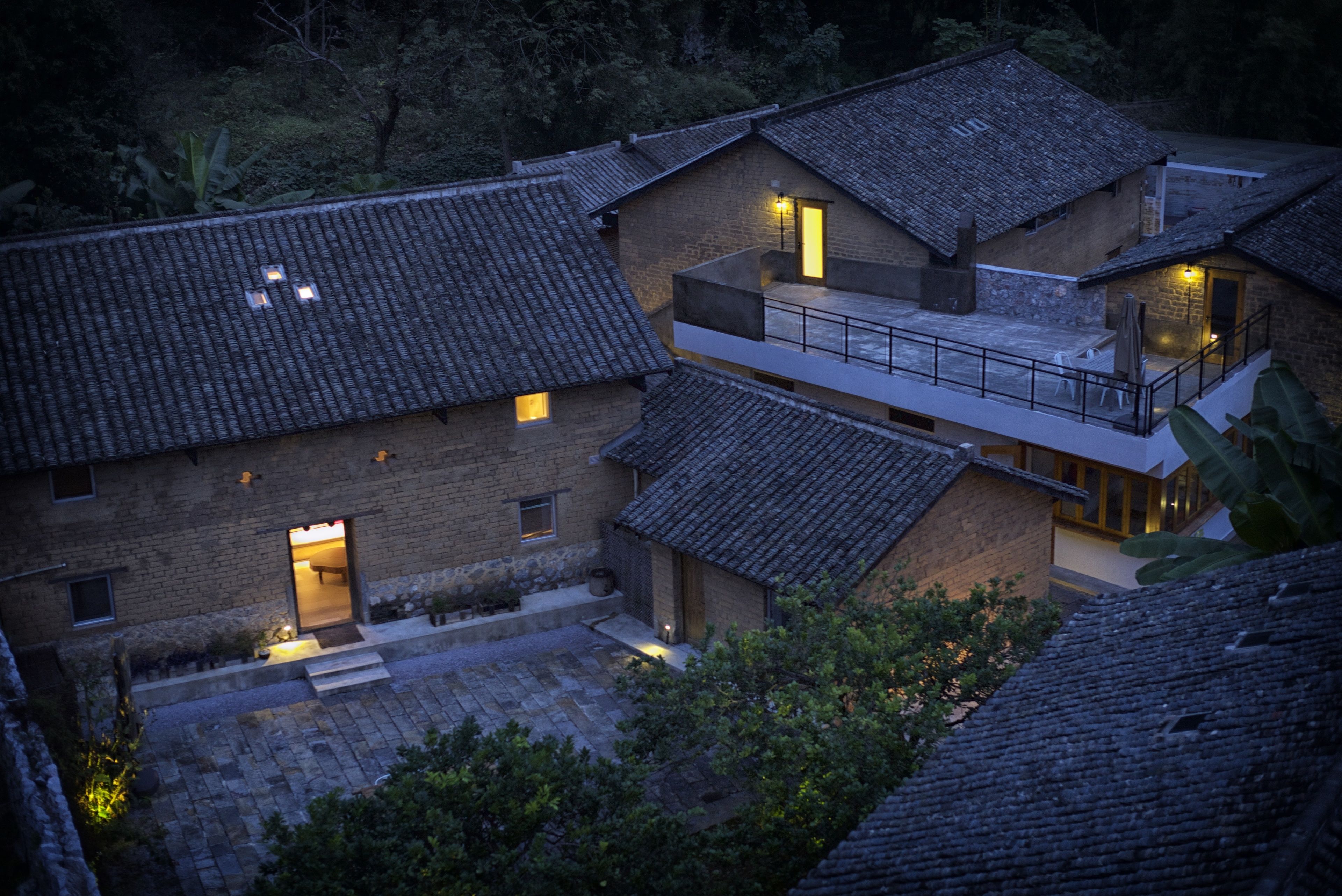 A traditional building with multiple levels, a balcony, and a well-lit entrance.