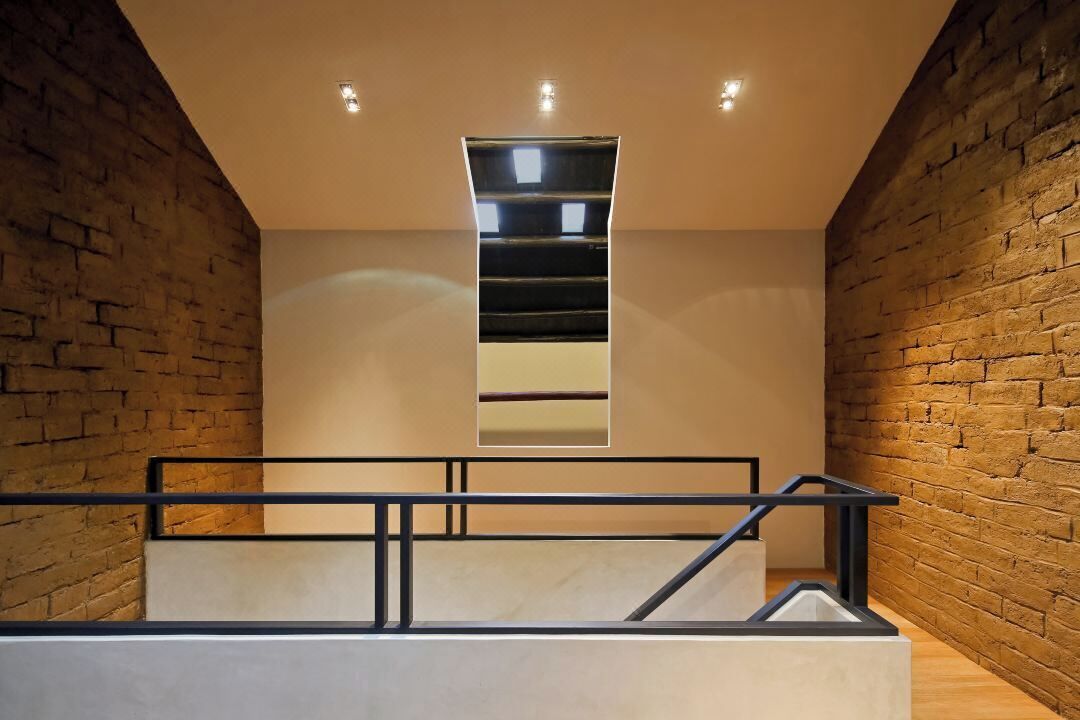 Un interior moderno con una escalera, paredes de ladrillo y un diseño minimalista.