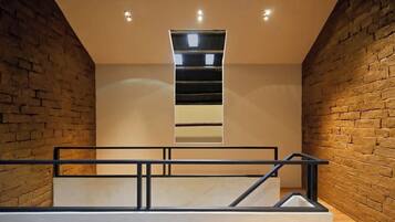 Un interior moderno con una escalera, paredes de ladrillo y un diseño minimalista.