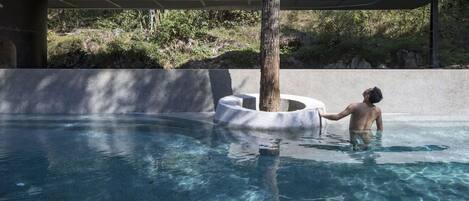 Utomhuspool, infinity-bassäng, parasoller och solstolar