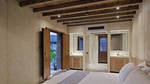 A bedroom with a large bed, two wooden cabinets, a mirror, and a door leading to a balcony with a view of greenery. - XY YunHouse (Guilin)