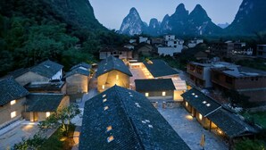 A traditional village with stone houses and a mountainous backdrop. - XY YunHouse (Guilin)