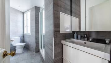 Une salle de bain moderne équipée de toilettes, d’une douche et d’un lavabo.