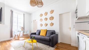 Una sala de estar moderna con un sofá, una mesa de centro y un comedor con sillas.