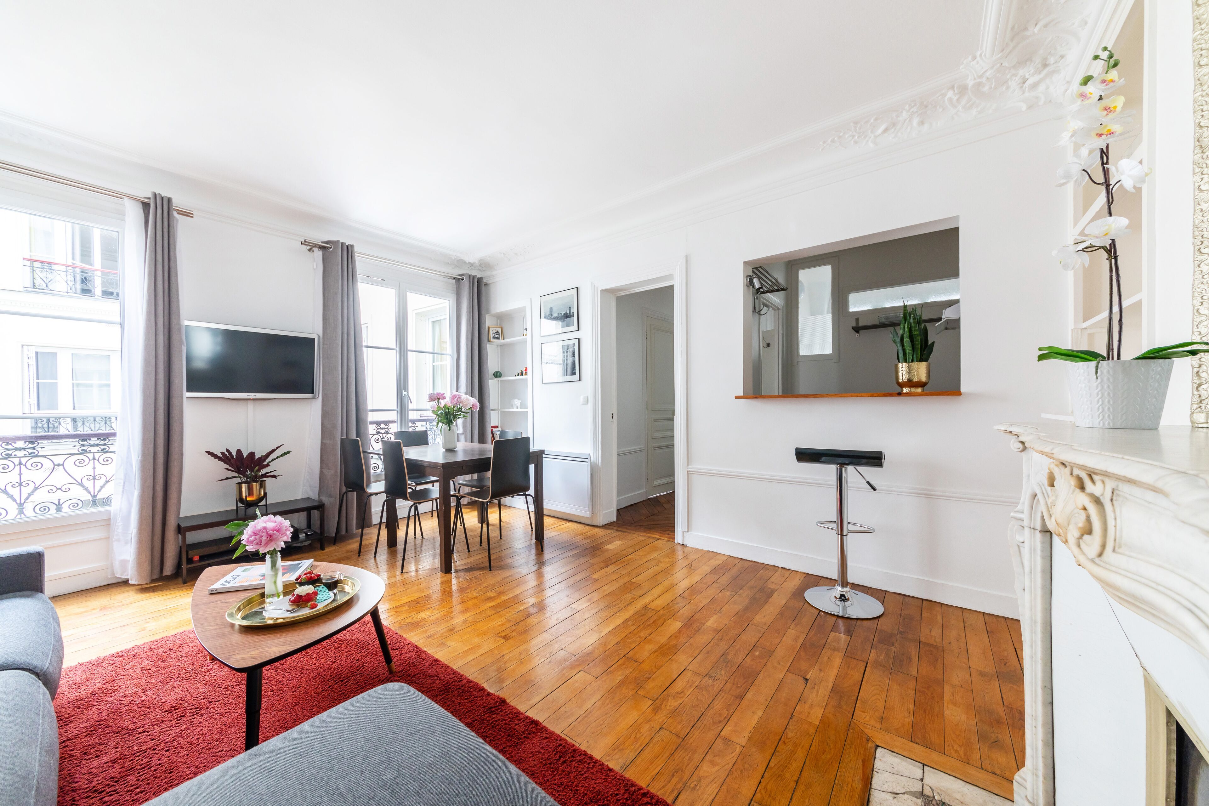 Ein modernes Wohnzimmer mit Kamin, Essbereich und Wand-Fernseher.