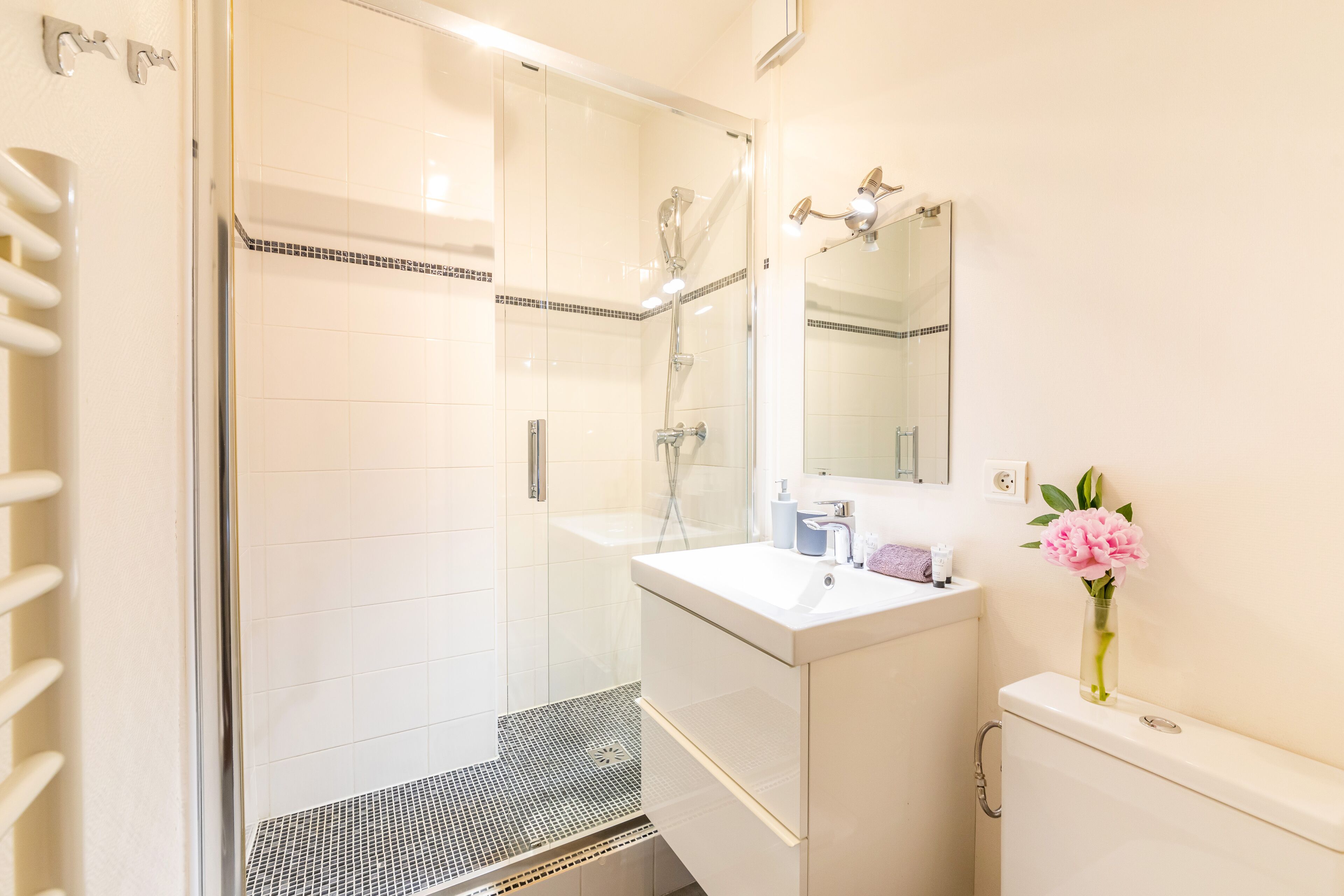 A bathroom with a shower, a sink, and a mirror.