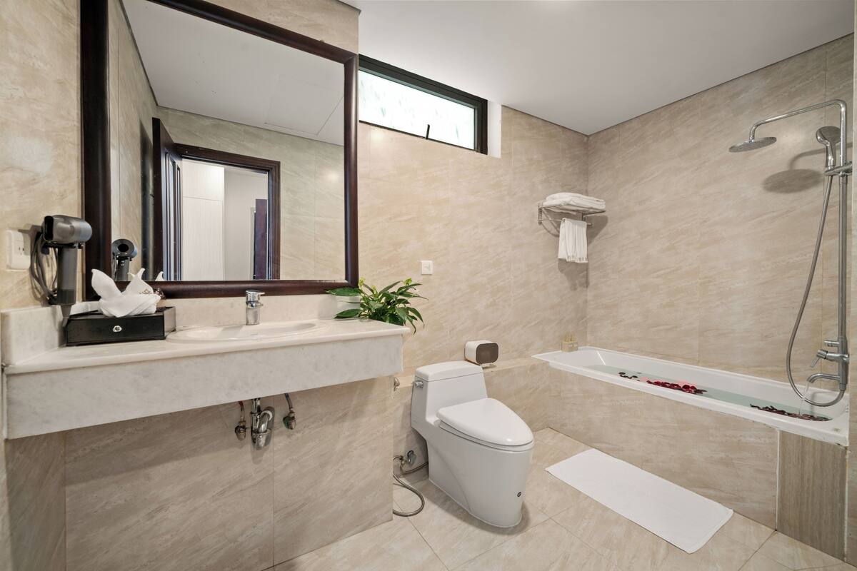 A modern bathroom with a toilet, sink, and bathtub.