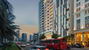 A modern hotel building with multiple floors, large windows, and a prominent sign. - Lunar Hotel Danang (Da Nang)