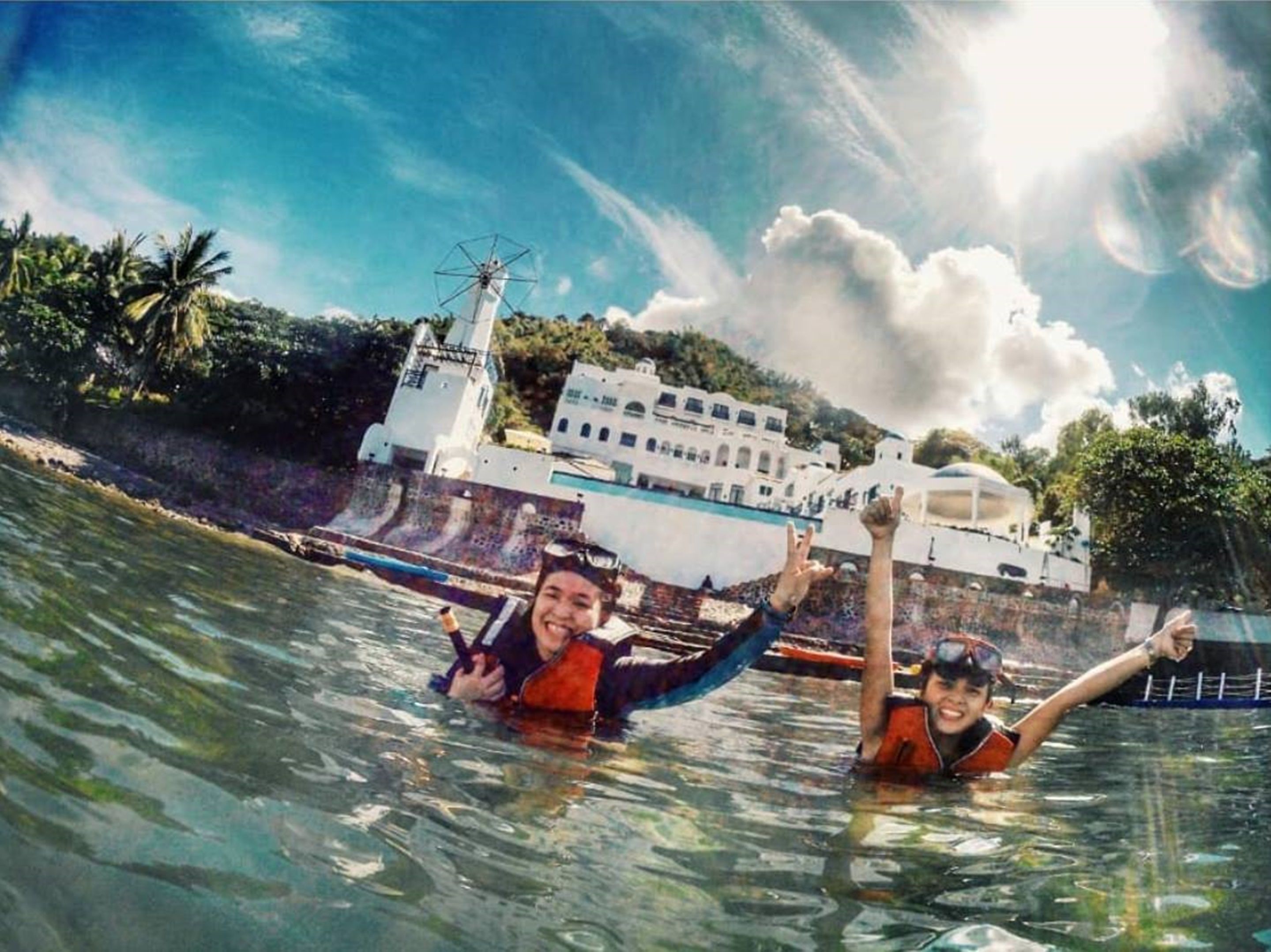 Two people in a boat with a large white building in the background.