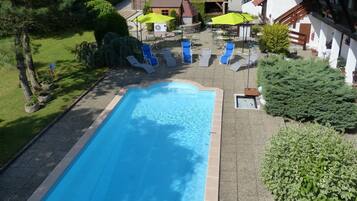 Alberca al aire libre por temporada y sombrillas en la alberca