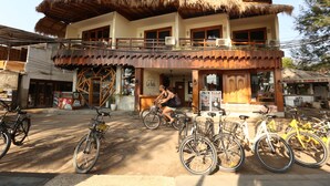A two-story building with a thatched roof and a balcony. - La Bella - Hotel Villa & Spa (Gili Trawangan)