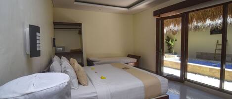 A hotel room with two beds, a bathroom, and a large sliding glass door leading to a pool area.