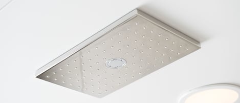 A ceiling with a recessed light fixture and a ventilation grille.