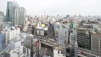 A cityscape with high-rise buildings, a busy street, and a prominent tower in the distance.