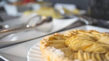 Ein Nahaufnahme von einem Dessert mit Kreuzmuster auf einem weißen Teller, mit Küchenutensilien im Hintergrund.