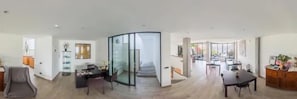 A spacious living area with a dining table, seating, and a glass partition. - B&B Vista Lago (Como)