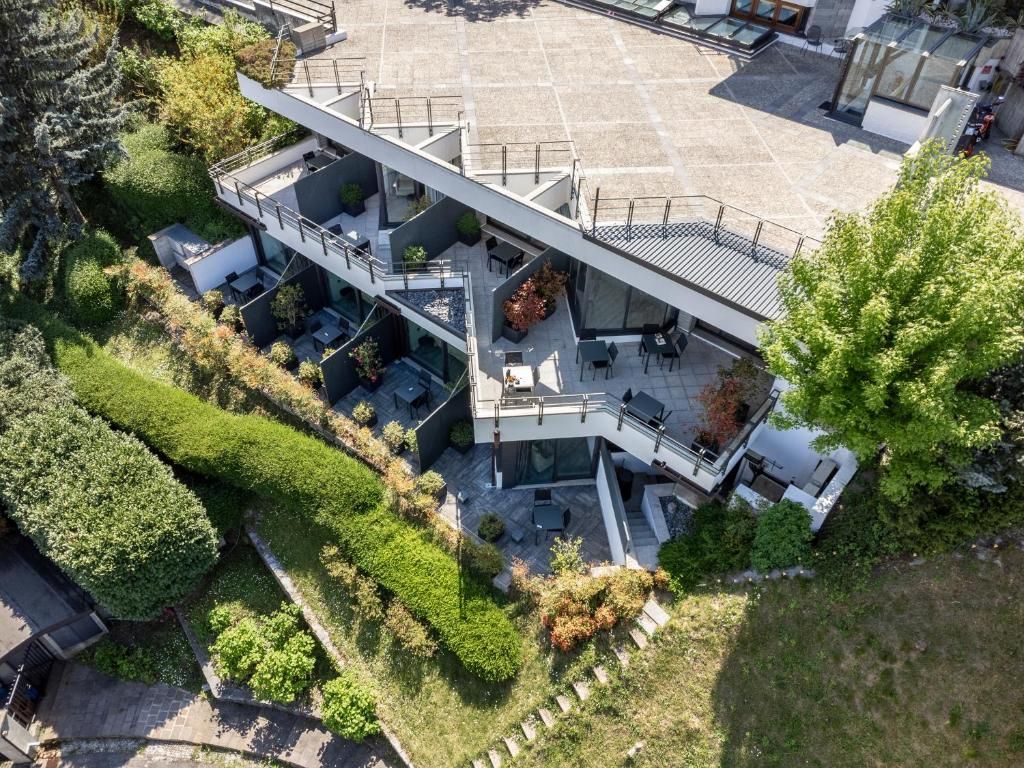 Un edificio moderno de varios pisos con zonas de estar al aire libre y una terraza en la azotea.