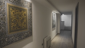 A hallway with patterned wallpaper, a radiator, and a staircase in the background. - B&B Vista Lago (Como)