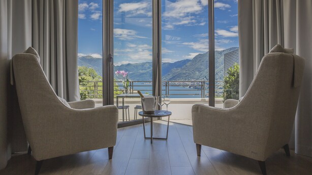A room with two armchairs facing a large window with a mountain view. - B&B Vista Lago (Como)