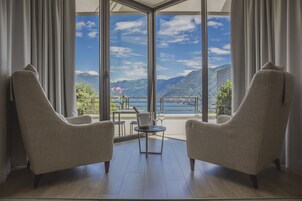 Una habitación con dos sillones mirando hacia una ventana grande con vistas a la montaña.