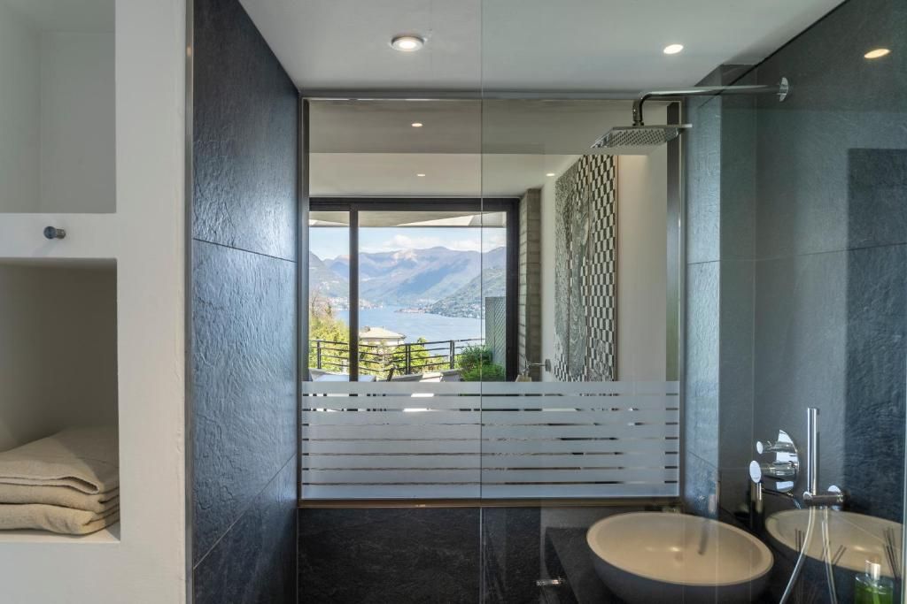 Un baño moderno con un amplio ventanal, una bañera y dos lavamanos.