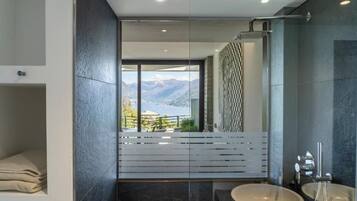 Un baño moderno con un amplio ventanal, una bañera y dos lavamanos.