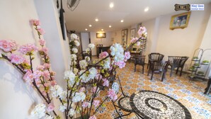 A dining area with a tiled floor, a round table with a patterned top, and chairs. - Ming Shou Boutique House (Phuket)
