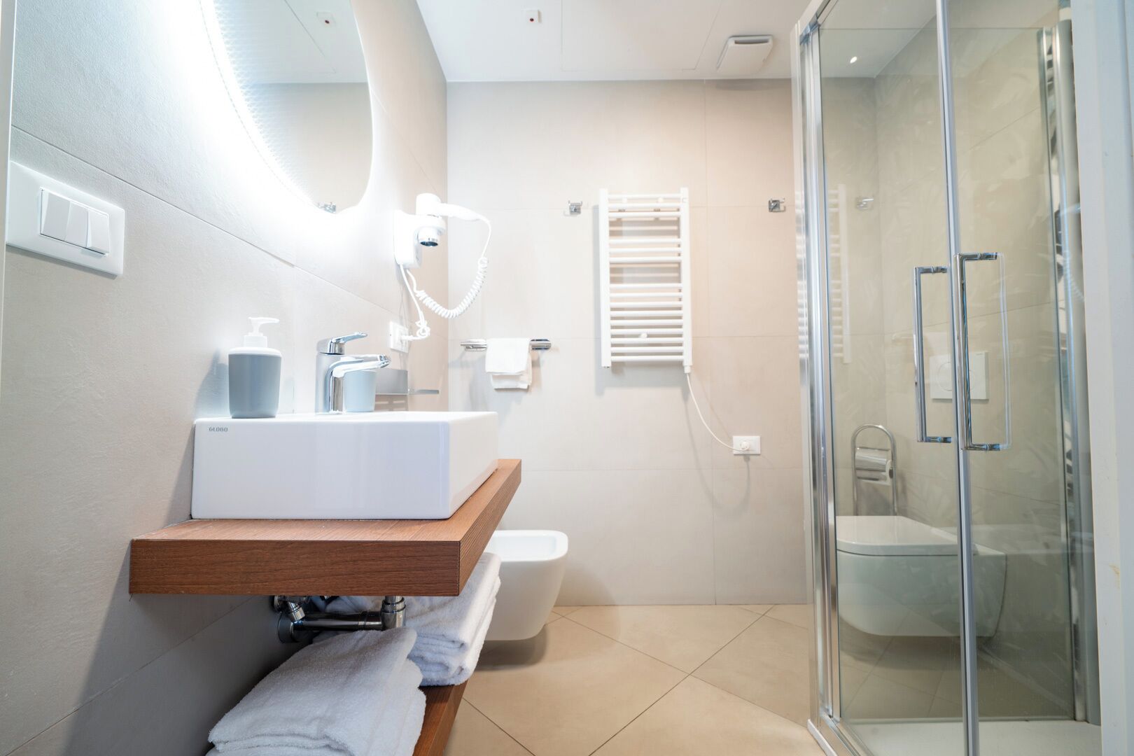 Une salle de bain moderne avec un lavabo blanc, une douche en verre et des toilettes.