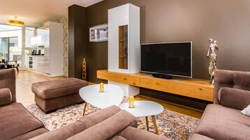 Ein modernes Wohnzimmer mit Flachbildfernseher, braunen Sofas, einem weißen Couchtisch und einer Holzkonsole.