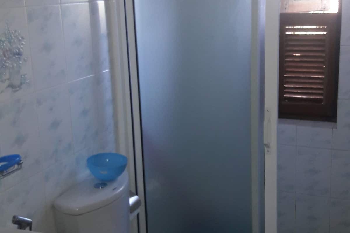 A bathroom with a toilet, a sink, and a shower enclosure.