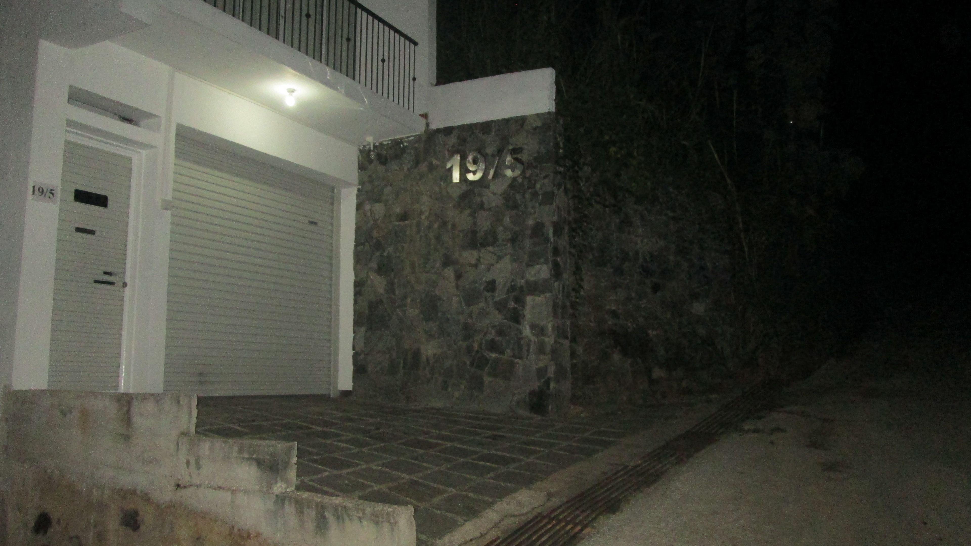 A building with a stone facade, a garage door, and a small staircase leading up to the entrance.