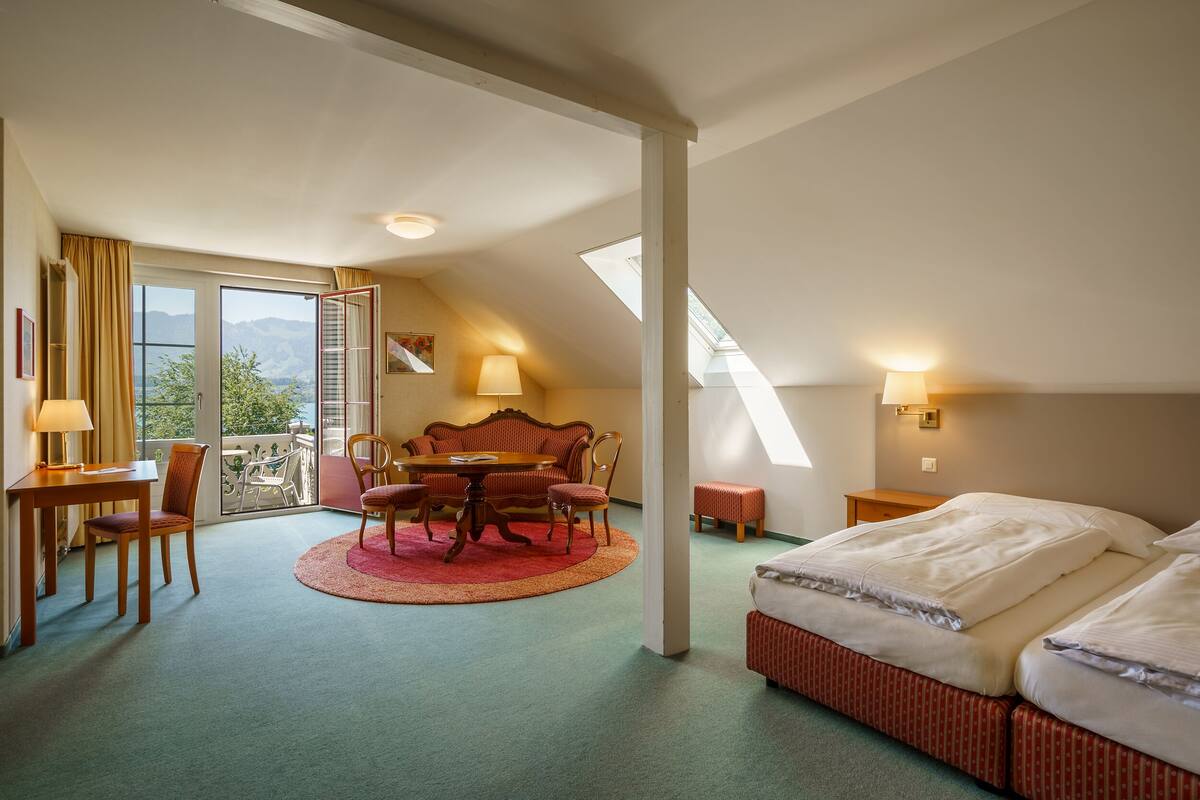 Een hotelkamer met een eethoek, een bed en een balkon met uitzicht.