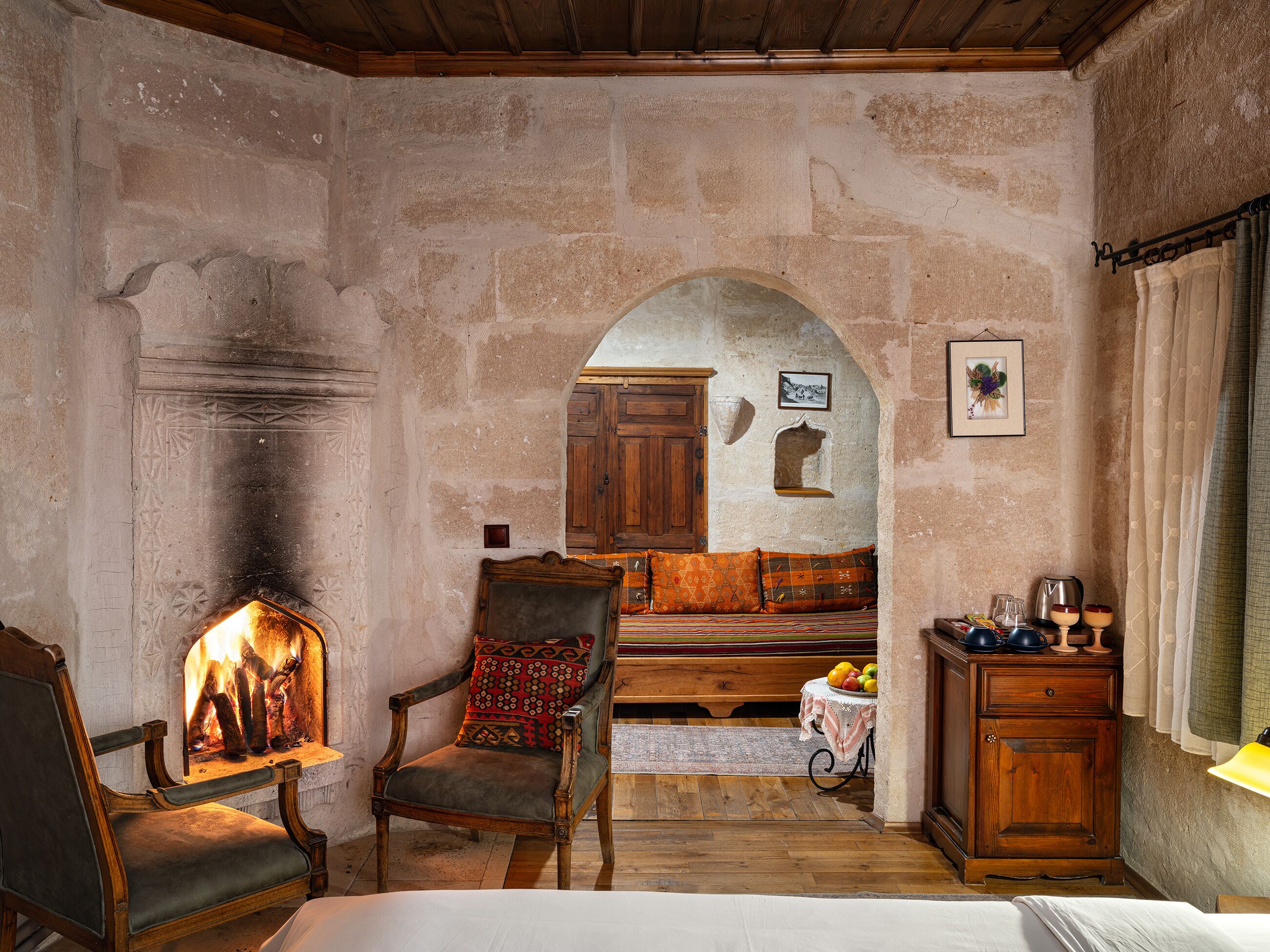 Una habitación rústica con chimenea, muebles de madera y paredes de piedra.