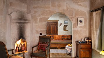 Una habitación rústica con chimenea, muebles de madera y paredes de piedra.