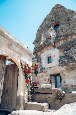 A stone building with a wooden door and a small window. - Kelebek Cave Hotel (Nevsehir)