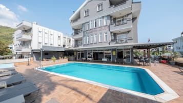 Een buitenzwembad en ligstoelen